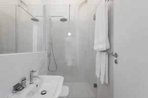 a white bathroom with a sink and a shower at The White Box Boutique House in Porto