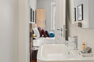 a bathroom with a sink and a mirror and a couch at The White Box Boutique House in Porto +85 photos