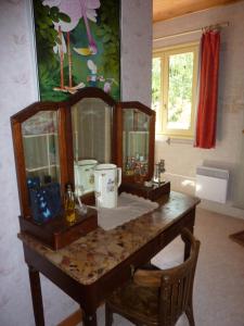 een tafel met een spiegel en een stoel in een kamer bij Gîte des Gorges du Bruyant in Saint-Nizier-du-Moucherotte