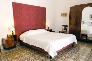 a bedroom with a large bed with a red headboard at Dimora Storica Palazzo Didonna in Rutigliano +23 photos