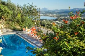 a swimming pool with chairs and a view of the water at Alkion in Georgioupolis