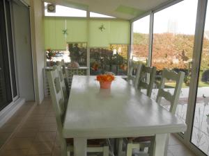 a white table and chairs in a room with windows at Le Rive De Saone in Verdun-sur-le-Doubs