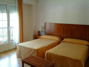 a hotel room with two beds and a window at Hotel Valcarce Camino de Santiago in La Portela de Valcarce