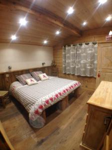 ein Schlafzimmer mit einem Bett in einer Holzhütte in der Unterkunft Chalet Coelacanthe in La Clusaz