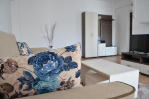 a living room with a couch with a floral pillow at Alexys Residence 6 in Iaşi