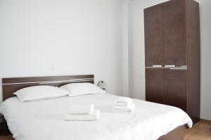 a bedroom with a bed with two white towels on it at Alexys Residence 6 in Iaşi