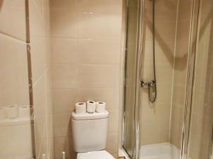 uma casa de banho com um WC e um chuveiro com 2 rolos de papel higiénico em Be 1 of Us Central Lisbon Bairro Alto Santa Catarina em Lisboa