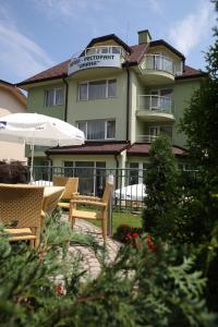 a hotel with chairs and an umbrella in front of it at Family Hotel Diana in Sofia