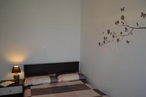 a bedroom with a bed and a tree stenciled on the wall at Matea in Kringa
