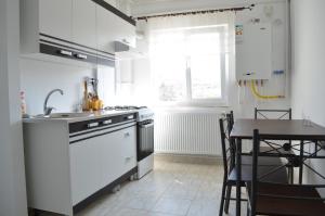 ヤシにあるAlexys Residence 8の白い家電製品とテーブル付きのキッチン