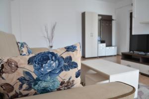 ein Wohnzimmer mit einem Sofa und einem Blumenkissen in der Unterkunft Alexys Residence 8 in Iaşi