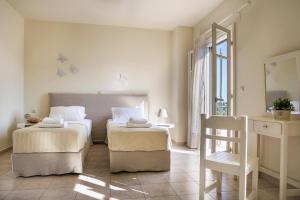 フィスカルドにあるVilla Isalosのベッドルーム1室(ベッド2台、椅子、窓付)