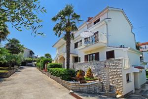 una casa blanca con una palmera delante de ella en Apartments Marija, en Poreč