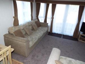 a living room with a couch and some windows at 3 Bedroom Caravan in Tattershall