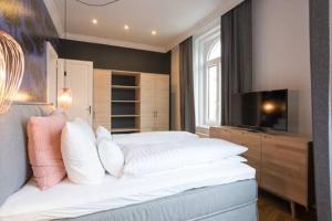 Schlafzimmer mit einem großen weißen Bett und einem TV in der Unterkunft My Home in Vienna - Smart Apartments - Margareten in Wien