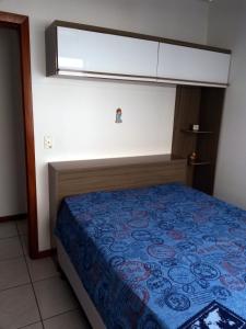 1 dormitorio con 1 cama con colcha azul en Apartamento em Meia Praia, Itapema, SC., en Itapema