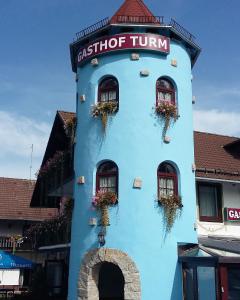 a blue building with windows and plants on it at Pension Turm in Schönwald