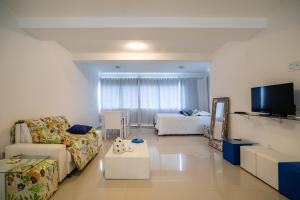 a living room with a couch and a tv at Casa Praia Pitinga in Arraial d'Ajuda