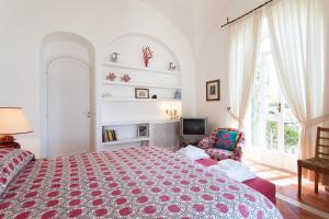 a bedroom with a large bed and a chair at Casa Bellevue in Positano