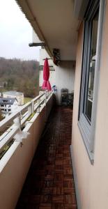 a balcony with a red umbrella on the side of a building at Sehr Schöne drei Zimmer Delüx Wohnung in Sindelfingen in Sindelfingen