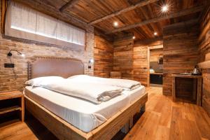 a large bed in a room with wooden walls at LMC Guesthouse in Ledro +52 photos