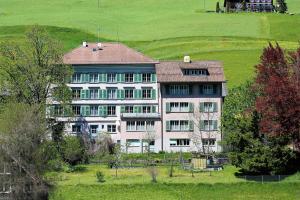 a large white building in the middle of a field at Galluszentrum in Wildhaus