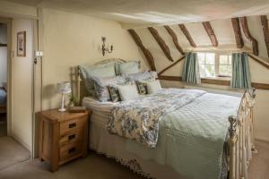 ein Schlafzimmer mit einem Bett und einem Fenster in der Unterkunft Old Fox Cottage in Evesham