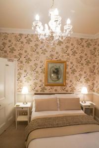 a bedroom with a bed and a chandelier at Hedley Villa Guest House in Leamington Spa