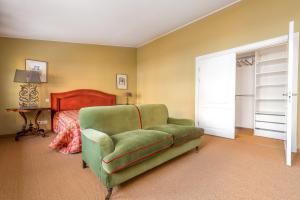 - une chambre avec un canapé vert et un lit dans l'établissement Angel House Vilnius, 4A, à Vilnius