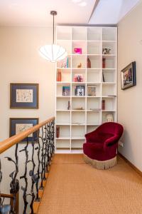 un salon avec une étagère et une chaise rouge dans l'établissement Angel House Vilnius, 4A, à Vilnius