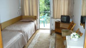 a bedroom with a bed and a tv and a balcony at Hotel Briz 3 - Free Parking in Varna City