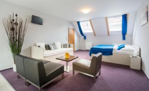 فندق أديبا في براغ: غرفة صغيرة بها سرير وأريكة