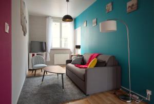 a living room with a couch and a blue wall at " Le cardinal " Fécamp Bord de mer in Fécamp
