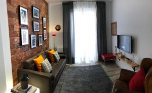 a living room with a couch and a brick wall at Landatxoenea in Bilbao
