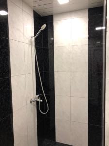 y baño con ducha y azulejos blancos y negros. en Rest home Jermuk, en Jermuk