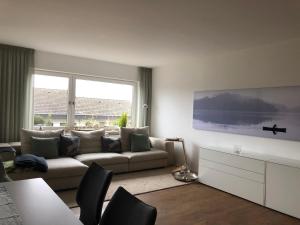 a living room with a couch and a large window at Wunderschönes Domizil auf der Höri am Bodensee in Gaienhofen