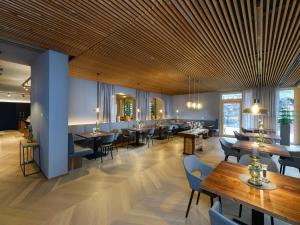 a restaurant with wooden ceilings and tables and chairs at Hotel Bergzeit in Grossarl