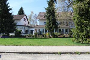 a large white house with trees in the yard at Hotel am Kurpark in Villingen-Schwenningen