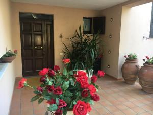 a vase filled with red flowers on a tile floor at Villa Graziella Perugia in Perugia