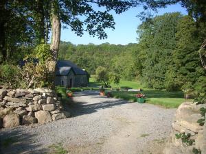 a gravel driveway leading to a stone wall and a house at The Old House in Carrick-on-Suir