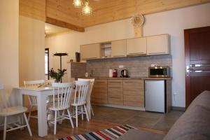 una cucina con tavolo e sedie bianchi e bancone di Apartamenty i pokoje u Klimka a Zakopane