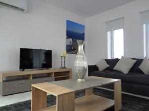 a living room with a couch and a vase on a table at Plage Residences in Paphos City