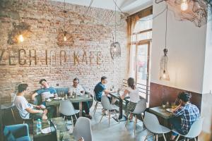 een groep mensen die aan tafel zitten in een restaurant bij Czech Inn in Praag