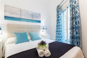 1 dormitorio con 1 cama con toallas en Del Parque Flats - Peña en Málaga