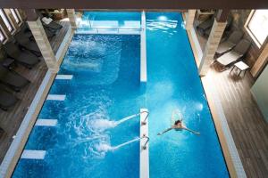 a woman swimming in a large swimming pool at Boutique Complex Trakiets in Duvanlii