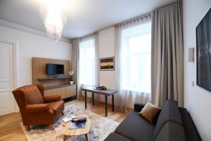 a living room with a couch and a chair at City Centre Chic Apartment Ljubljana 2/4 in Ljubljana