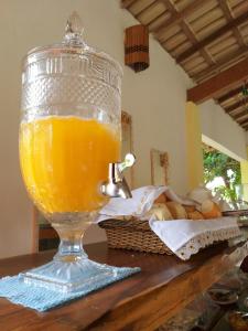 a glass jar of orange juice sitting on a table at Pousada Vida Mar in Barra Grande