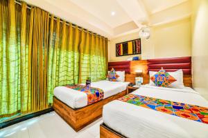 a hotel room with two beds and curtains at FabExpress Deluxe Comfort in Mumbai