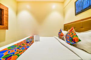 a bedroom with a large bed with colorful pillows at FabExpress Deluxe Comfort in Mumbai