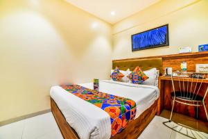 a bedroom with a bed and a chair in it at FabExpress Deluxe Comfort in Mumbai